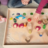 Children playing with a sensory small world using the Grapat freeplay tray, peg dolls and various small pieces