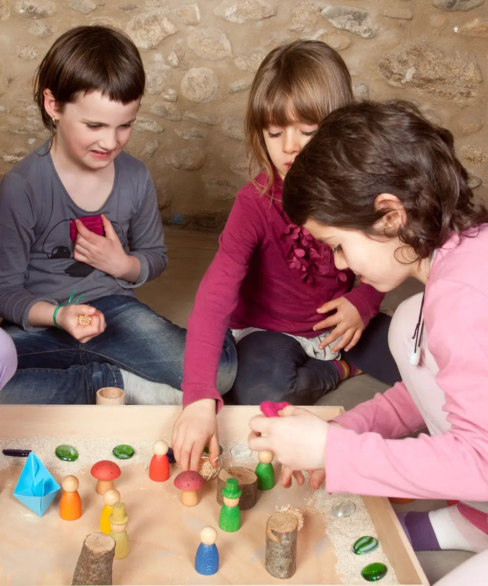 Children creating a small world using the Grapat freeplay tray, peg dolls and various small pieces