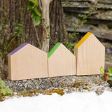 Grapat handcrafted wooden house shaped blocks with coloured roofs on a stone wall
