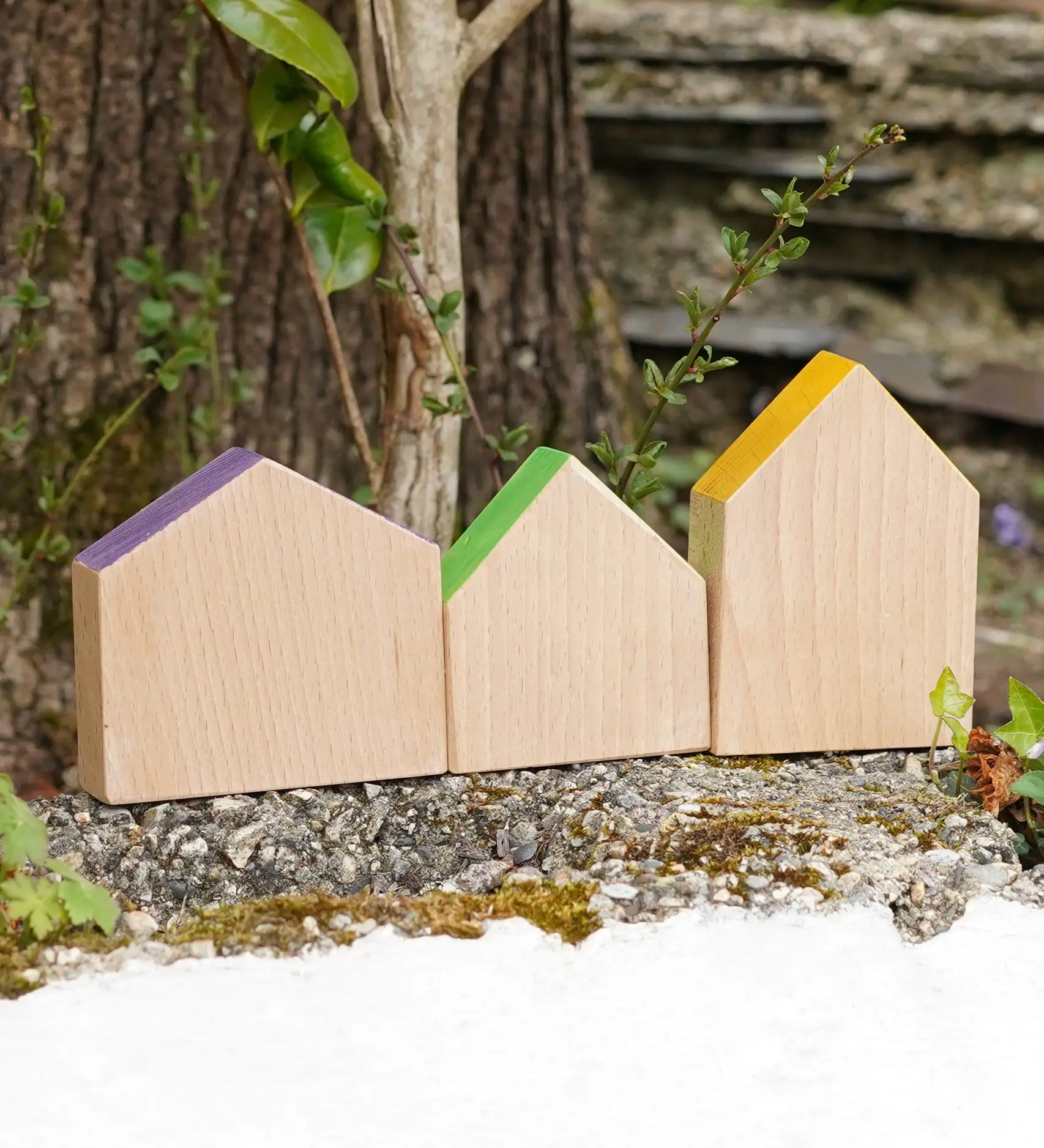 Grapat handcrafted wooden house shaped blocks with coloured roofs on a stone wall
