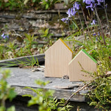 Grapat handcrafted wooden house shaped blocks with coloured roofs standing in a garden 