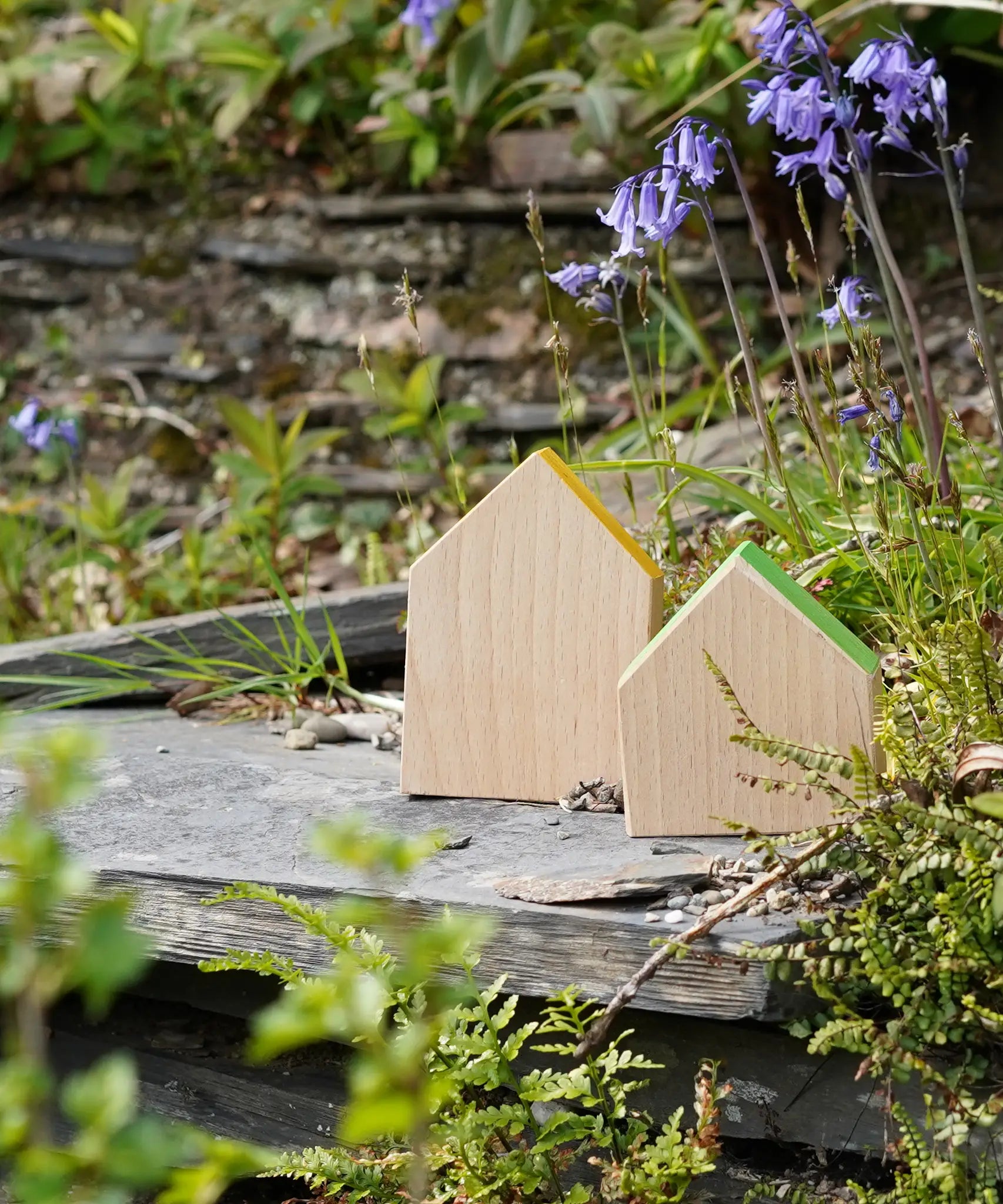 Grapat handcrafted wooden house shaped blocks with coloured roofs standing in a garden 