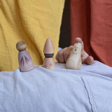 A child playing with three pieces from the Grapat Moonlight Tale Play Set. Various handmade and hand painted wooden figures of mushrooms.