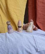 A child playing with three pieces from the Grapat Moonlight Tale Play Set. Various handmade and hand painted wooden figures of mushrooms.