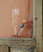 A close up of the handcrafted Grapat wooden twin soul puppet. Showing the orange fox and grey bear puppet played with behind a wooden window frame 