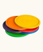 A stack of Grapat handcrafted wooden dishes in rainbow inspired colours