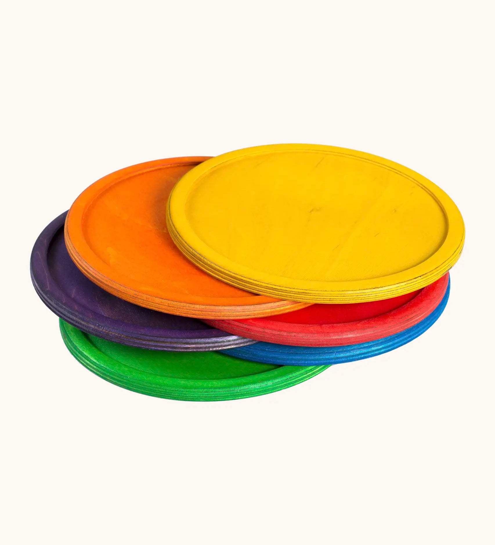A stack of Grapat handcrafted wooden dishes in rainbow inspired colours
