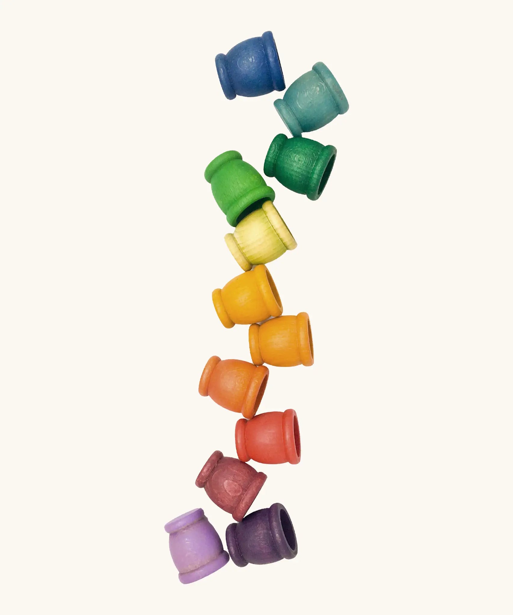 A set of 12 small handcrafted wooden Grapat curved cups in rainbow inspired colours