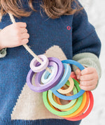 A child with the Grapat Wooden Nesting Rings strung on a rope. 