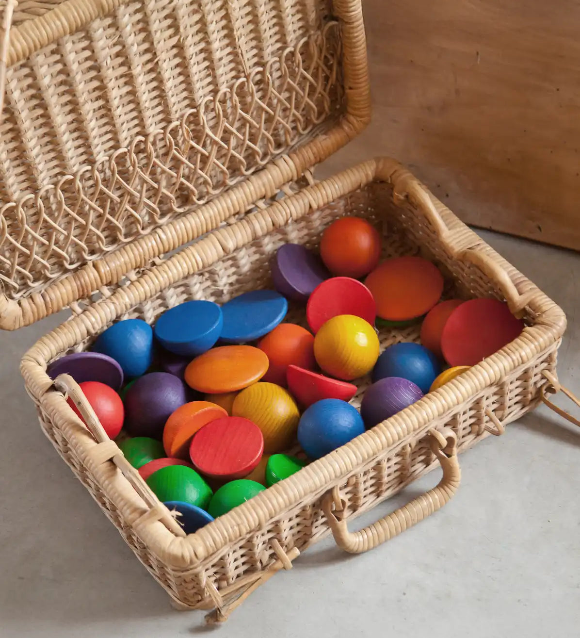 Grapat Loose Parts Rainbow Rounds Set placed in a basket hamper. 