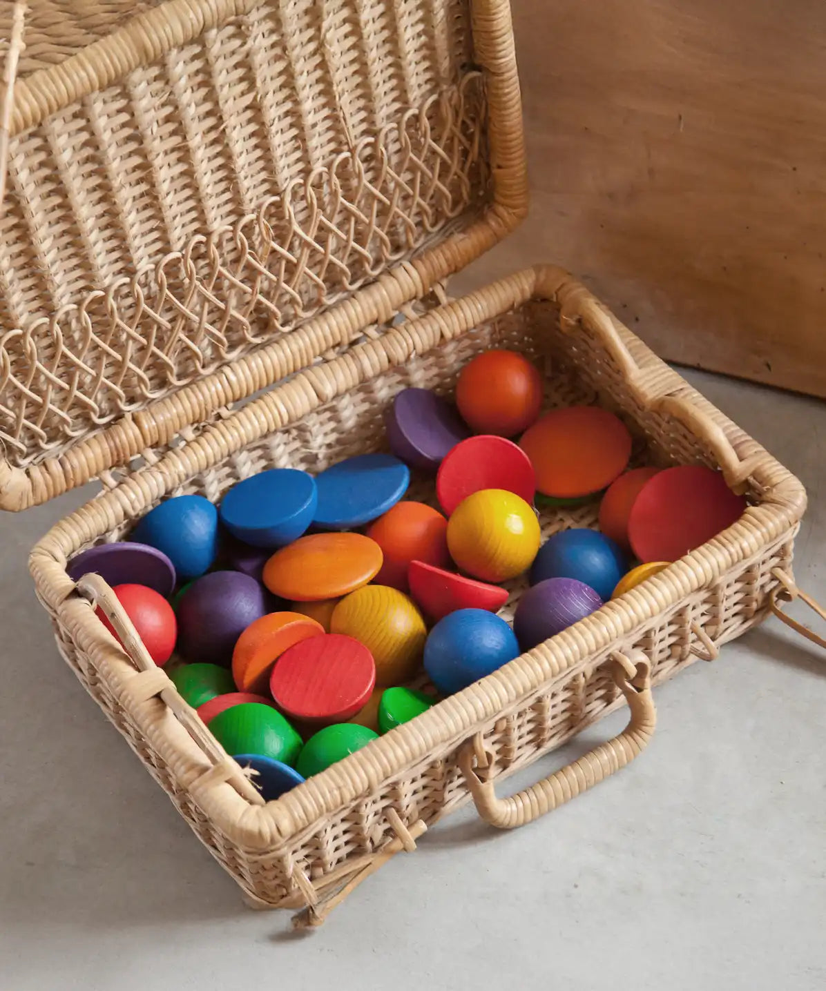 Grapat Loose Parts Rainbow Rounds Set placed in a basket hamper. 