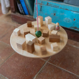 Grapat wooden pendulum set with wooden blocks on the balancing on the wooden balance board above a terracotta floor.