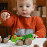 A child playing with the Bajo green Grasshopper wooden toy. These heirloom quality toys by Bajo are part of a wide range of wooden toys available here at Babipur.