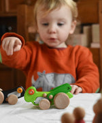 A child playing with the Bajo green Grasshopper wooden toy. These heirloom quality toys by Bajo are part of a wide range of wooden toys available here at Babipur.