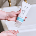 A person dispensing some product into their hand from the Green People After Sun 200ml tube. 