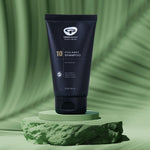 A tube of Green People no.10 Itch Away Shampoo placed on a  green coloured disc pictured against a green background. 