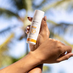 A person holding the Green People Natural and Organic Mineral Suncream SPF30 Scent Free bottle in their hand