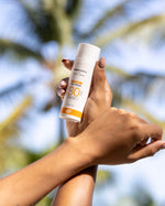A person holding the Green People Natural and Organic Mineral Suncream SPF30 Scent Free bottle in their hand