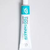 White and green branded tube of Green People minty cool toothpaste