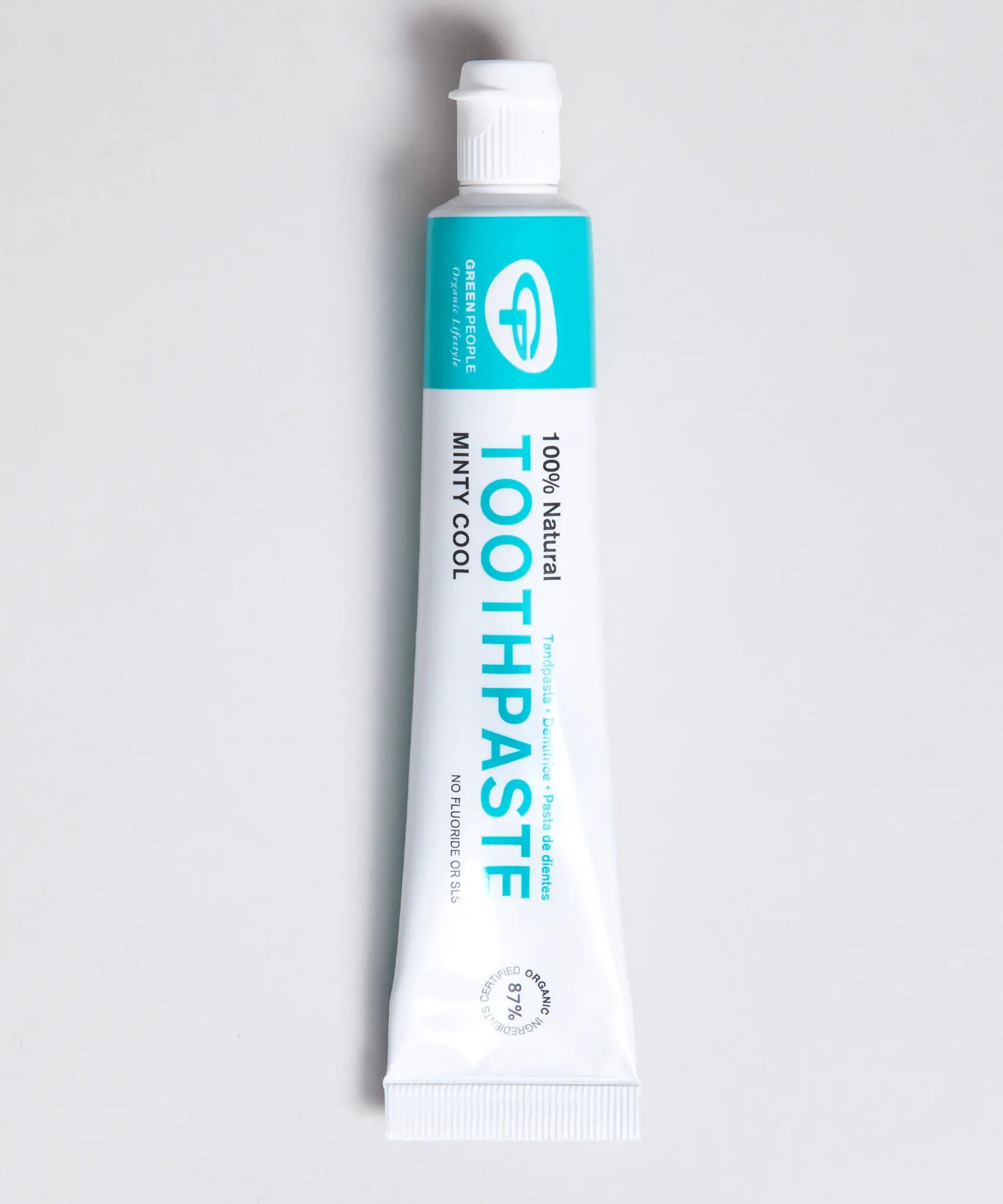 White and green branded tube of Green People minty cool toothpaste