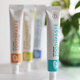 Tube of Organic People minty cool toothpaste standing next to other toothpastes 