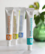 Tube of Organic People minty cool toothpaste standing next to other toothpastes 