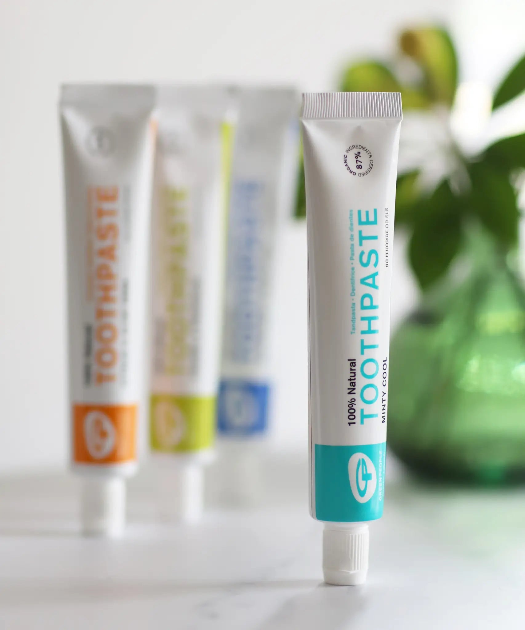 Tube of Organic People minty cool toothpaste standing next to other toothpastes 