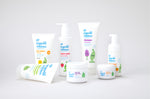 Green People's Organic Children range of baby friendly, natural washes, skincare and sun cream. The products are shown on a plain surface. 