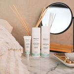 A collection of Green People organic facial care placed on a marble dressing table. A firming serum, a night cream and an eye serum. 