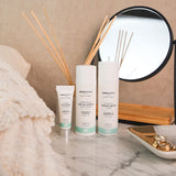 A collection of Green People organic facial care placed on a marble dressing table. A firming serum, a night cream and an eye serum. 
