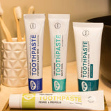 A collection of Green People natural toothpaste tubes in a bathroom