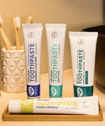 A collection of Green People natural toothpaste tubes in a bathroom