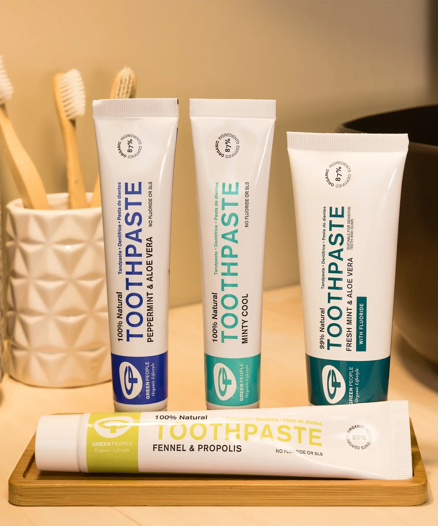 A collection of Green People natural toothpaste tubes in a bathroom