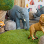 Green rubber toys eco-friendly lion figure perched on a papoose rock in front of a green rubber toys tiger and elephant
