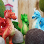 Close up of the Green rubber toys eco-friendly dragons stood between some papoose rock toys