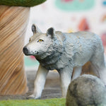 Close up of a green rubber toys eco-friendly wolf in front of a papoose wooden tree toy