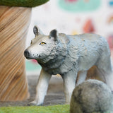 Close up of a green rubber toys eco-friendly wolf in front of a papoose wooden tree toy