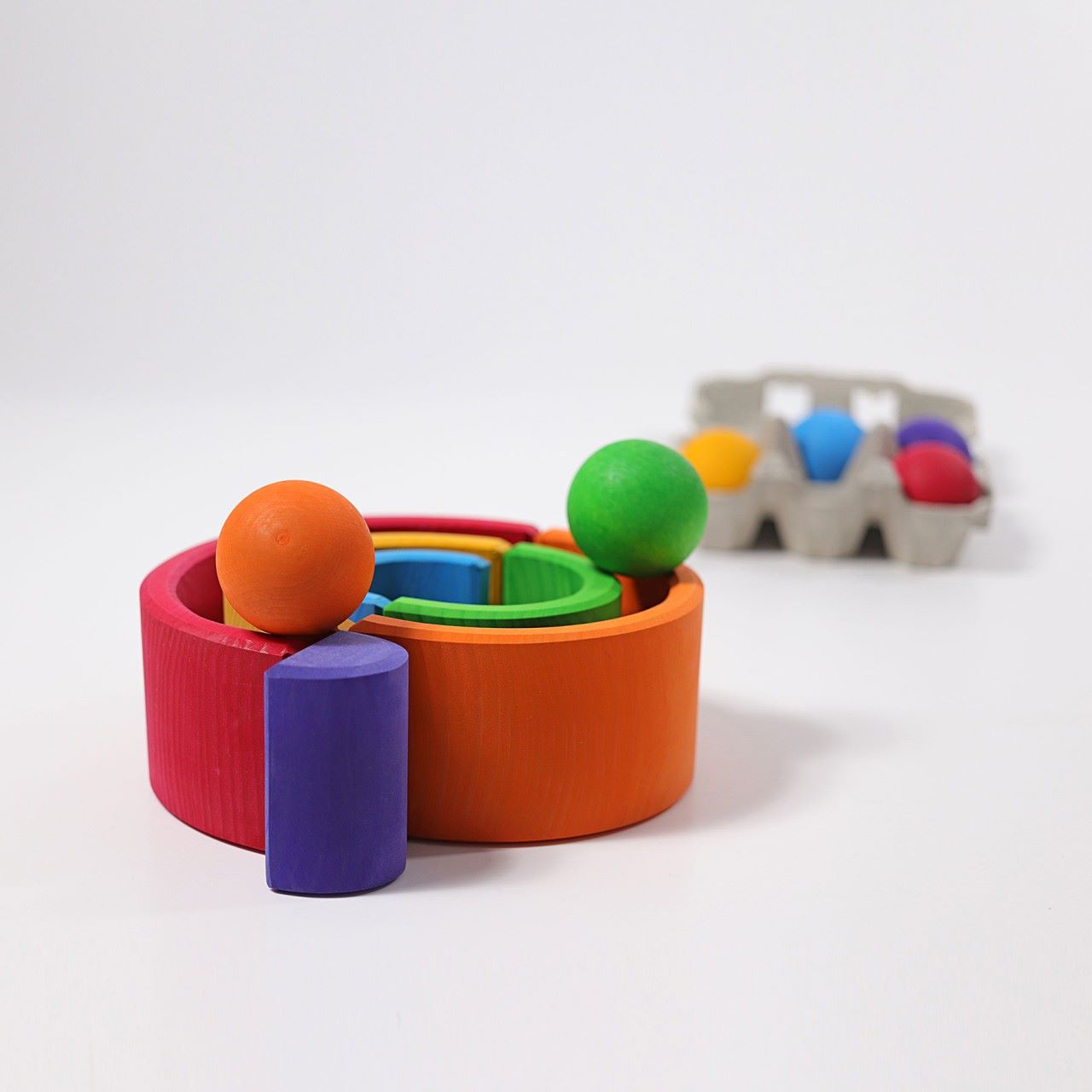 Grimm's Wooden Medium Rainbow as a ball run on a grey background