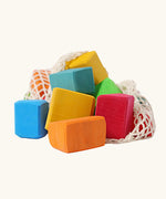 Grimm's 15 rainbow coloured wooden toy building blocks in a net storage bag.
