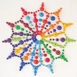 A mandala flatlay made from Grimms handcrafted wooden beads in a rainbow palette