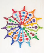 A mandala flatlay made from Grimms handcrafted wooden beads in a rainbow palette