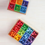 Grimms 20mm and 12mm handcrafted beads in a rainbow palette sorted into matching coloured trays