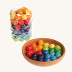 Rainbow coloured wooden Grimms beads in a wooden bowl and packaging on a cream background.