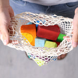 Grimm's 30 Coloured wooden Geo Blocks in their netting storage bag.
