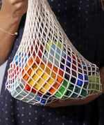 Grimm's 30 Coloured wooden Geo Blocks in their netting storage bag.