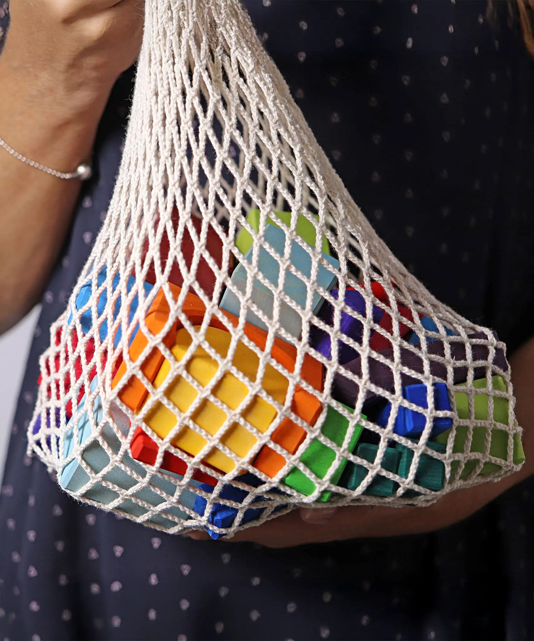 Grimm's 30 Coloured wooden Geo Blocks in their netting storage bag.