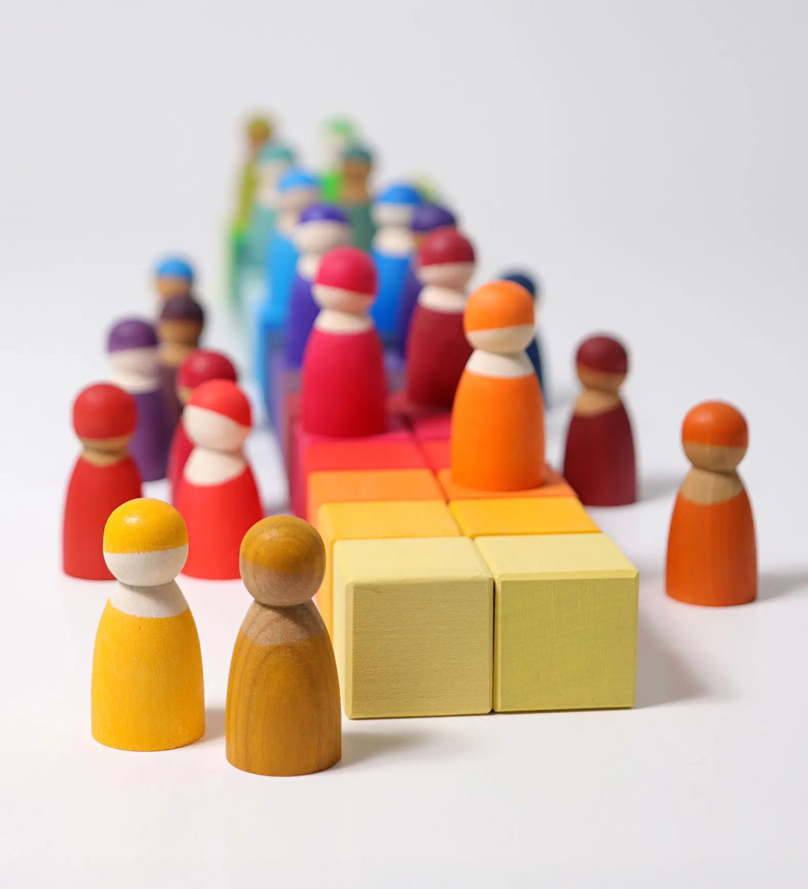 Grimm's 36 rainbow cubes wooden blocks with Grimm's rainbow friends placed on top. 