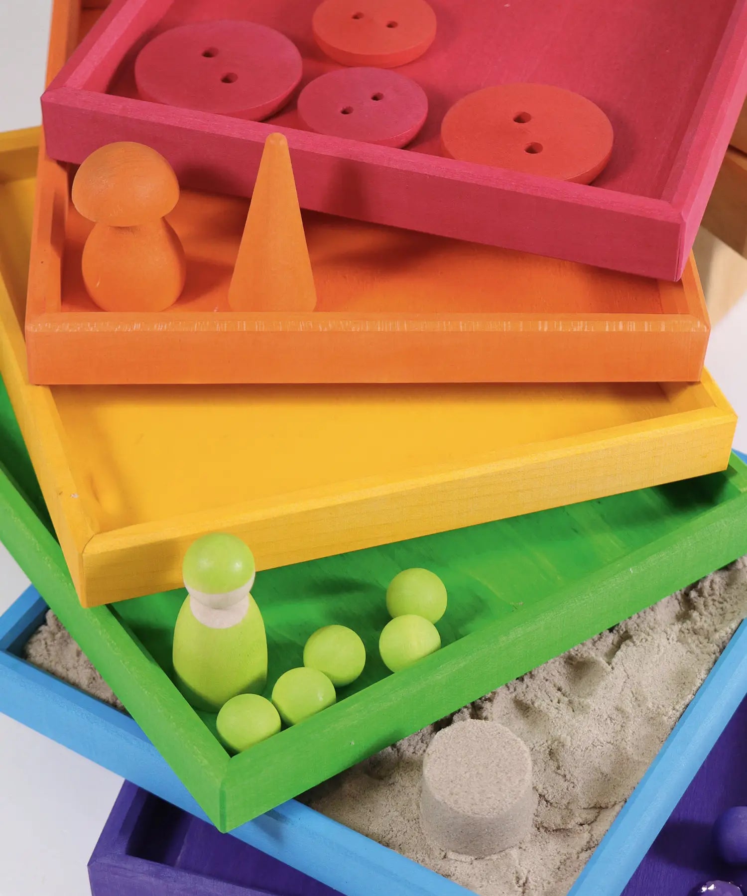 6 handcrafted wooden Grimm's frames in a rainbow palette showing little treasures stored in each frame