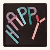 The word 'HAPPY' made from the Grimm's bright wooden A-Z curved and straight magnetic pieces displayed in a tin 