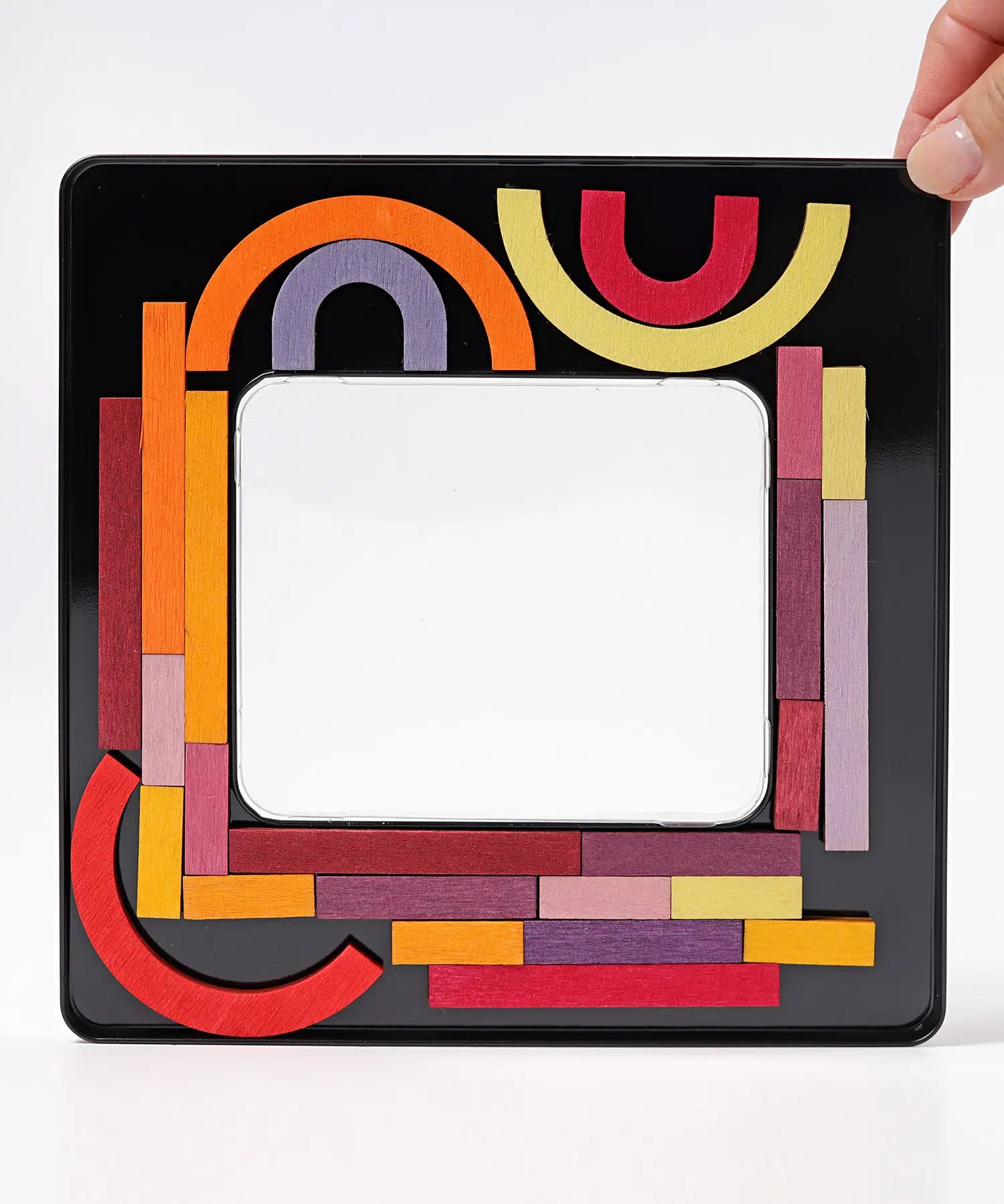 Inside of the tin with the Grimms wooden curved and straight magnetic pieces stuck on